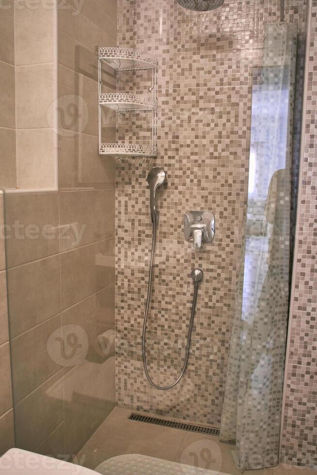 Modern bathroom shower with mosaic tiles and stainless steel fixtures photo