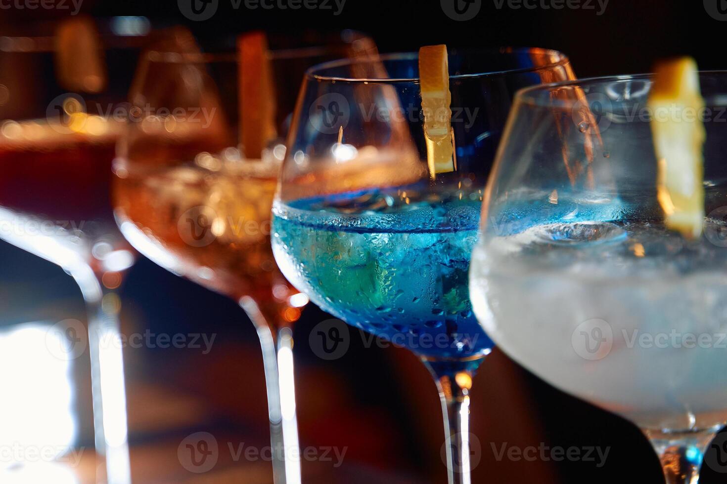 Vibrant cocktail display blue and orange drinks in elegant glasses photo