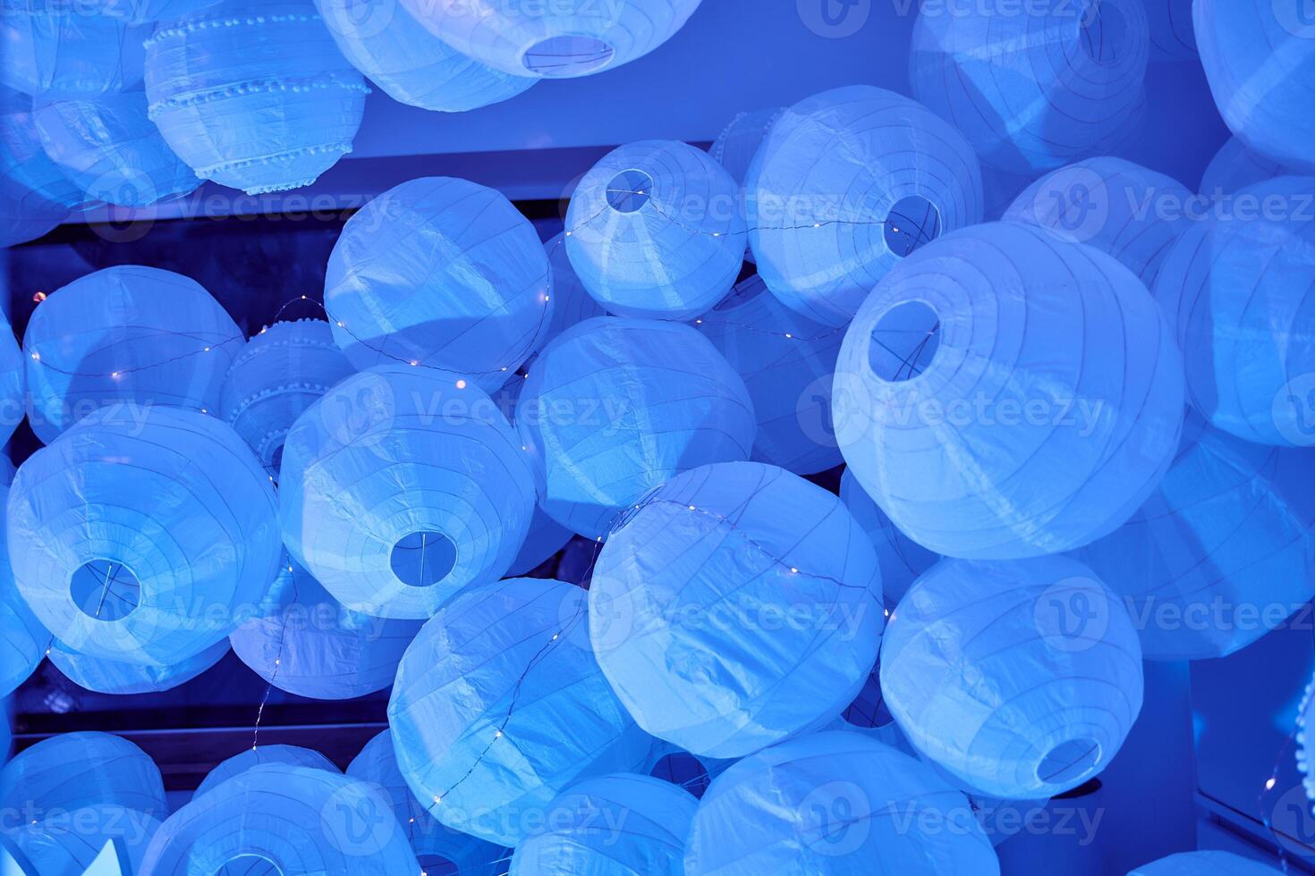 Blue lanterns illuminating indoor ceiling with soft glowing light photo