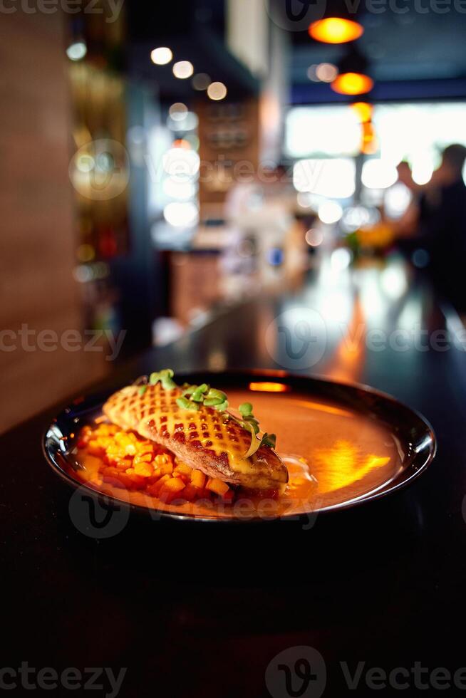 Exquisite gourmet dish grilled chicken, waffle garnish, elegant dining ambiance, culinary delight photo