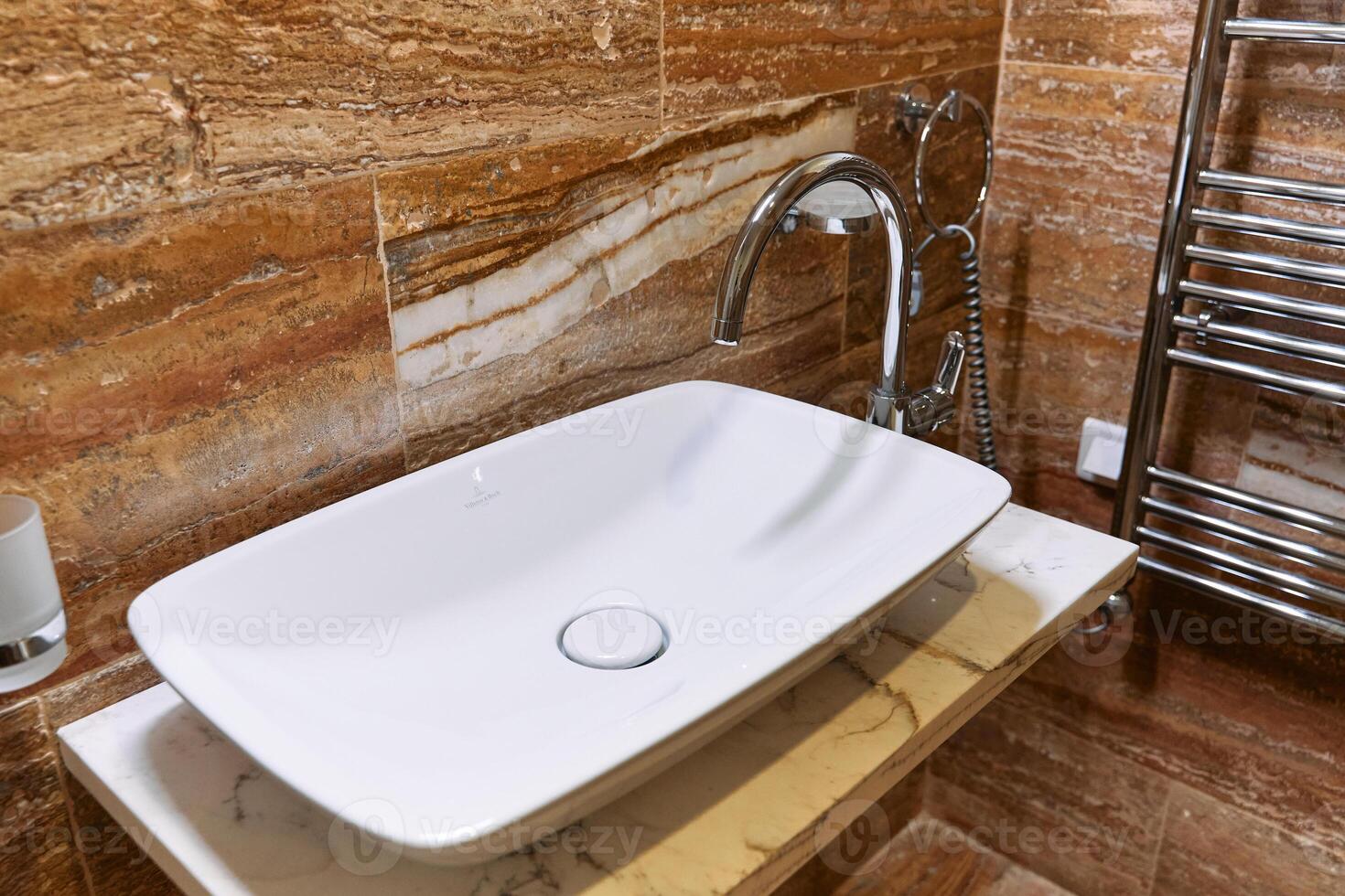 Modern bathroom with white sink and chrome faucet on marble countertop photo