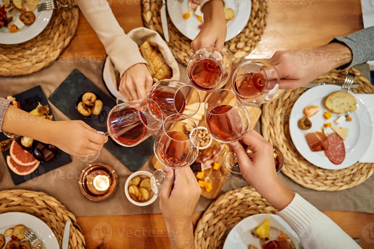 Celebration toast with friends over elegant dining setting featuring cheese and bread selections photo