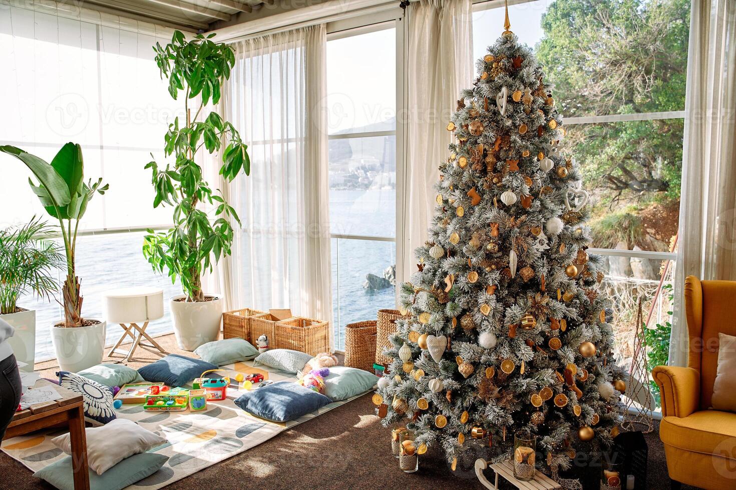 Festive room with christmas tree overlooking ocean view in cozy sunlit space photo