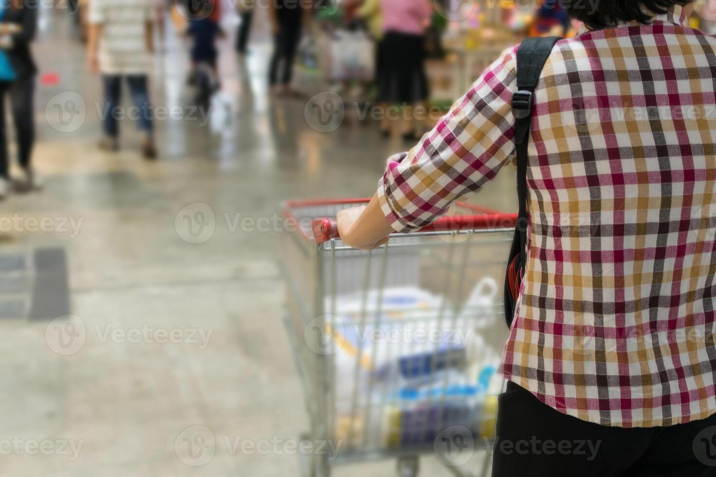 A woman pushing a shopping cart in a store photo