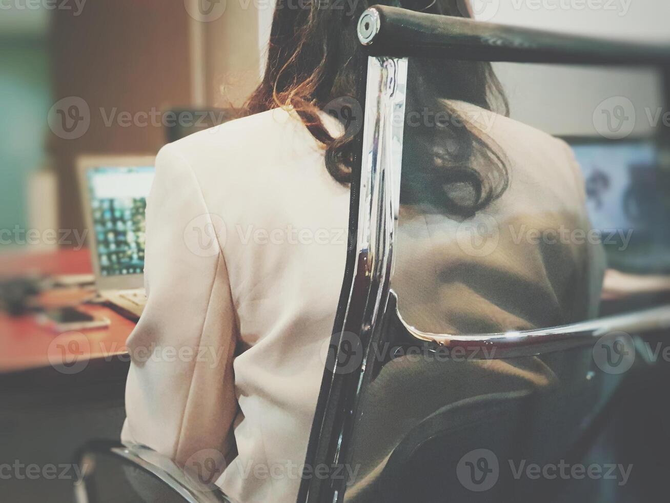 A woman sitting in a chair with a laptop photo