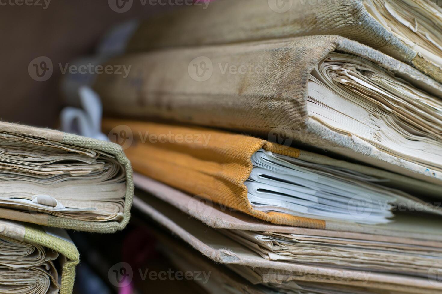 A pile of old documents sitting on top of a desk photo