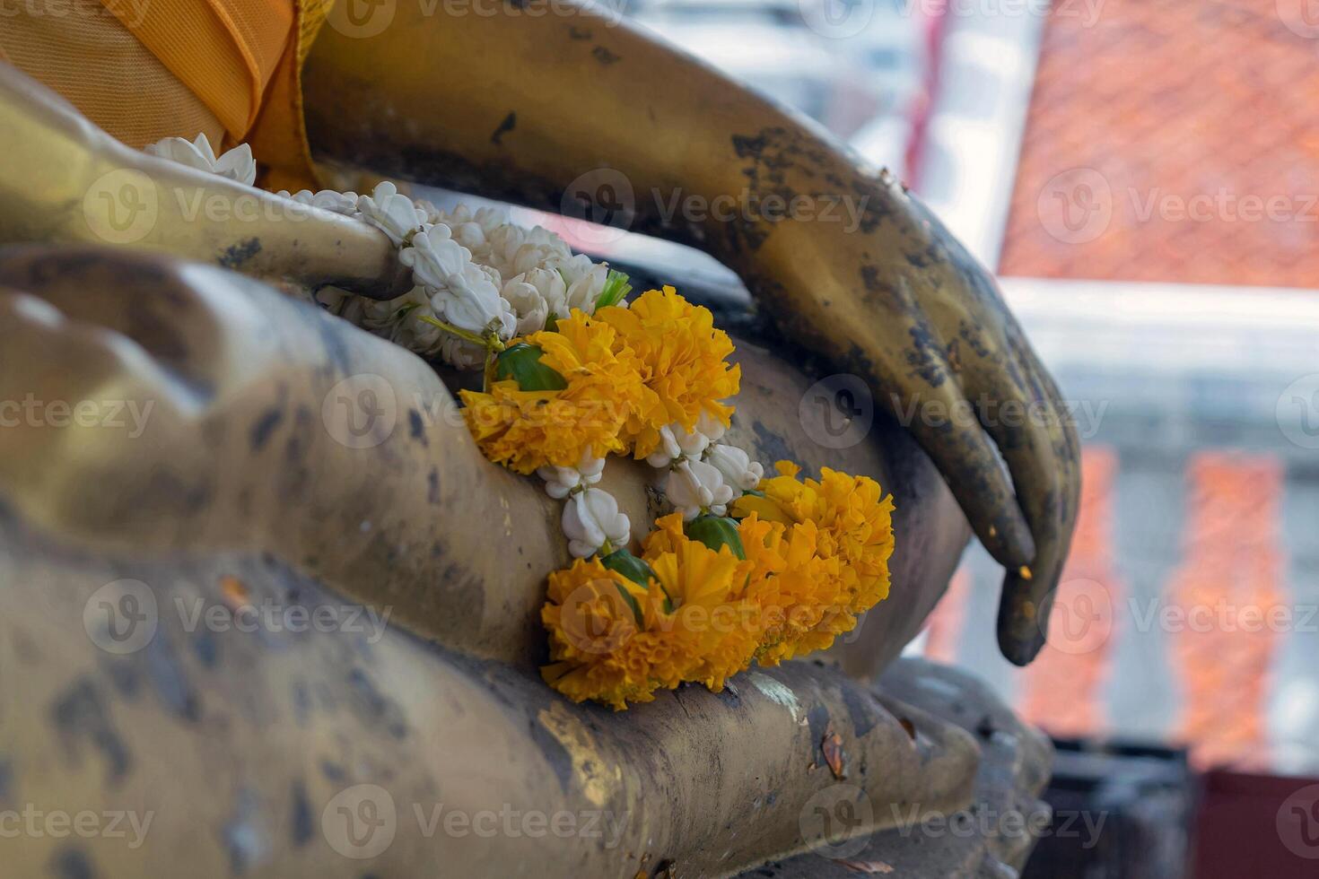 A statue of a buddha with flowers on it photo