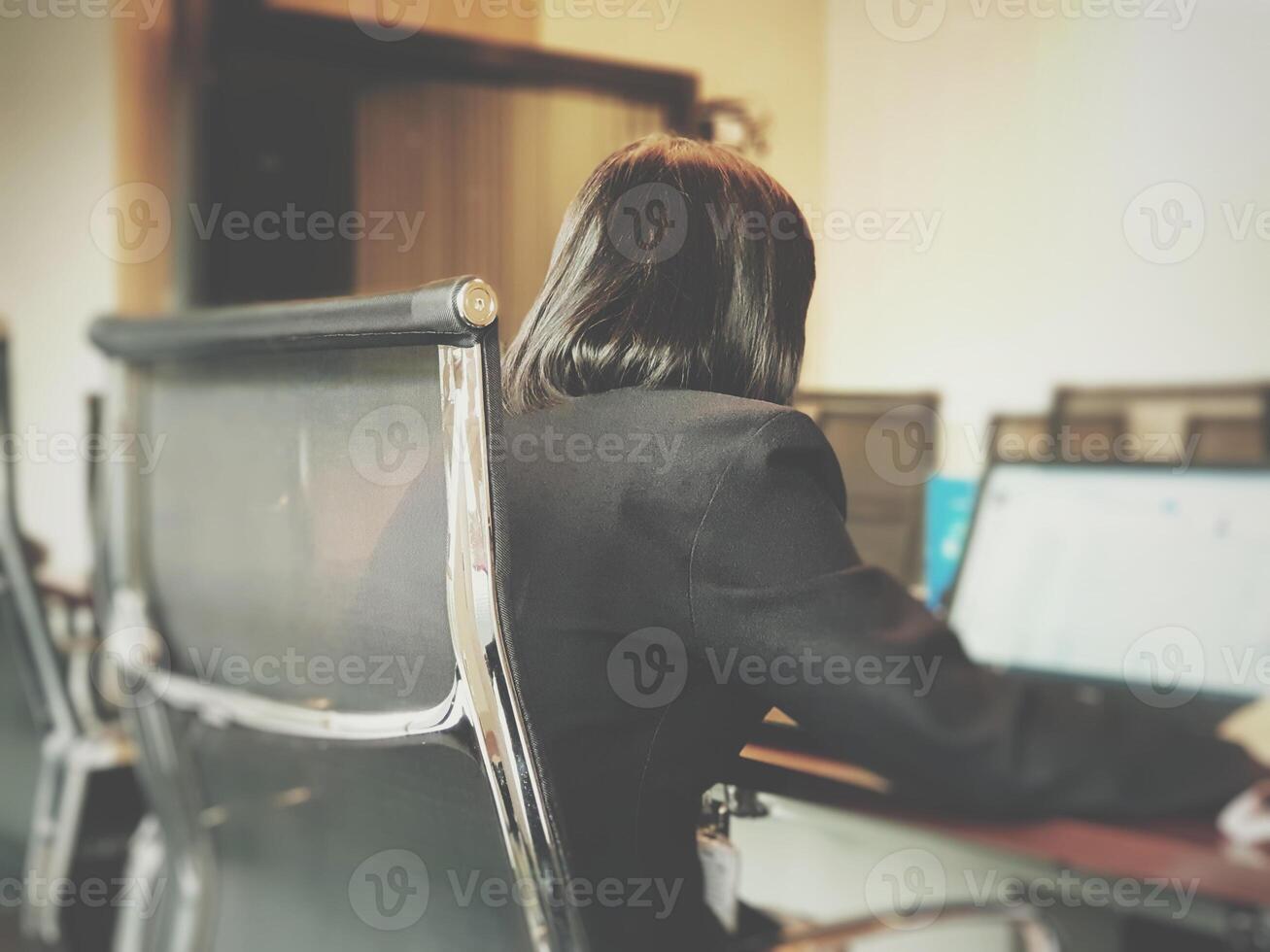 A woman sitting at a desk with a laptop photo