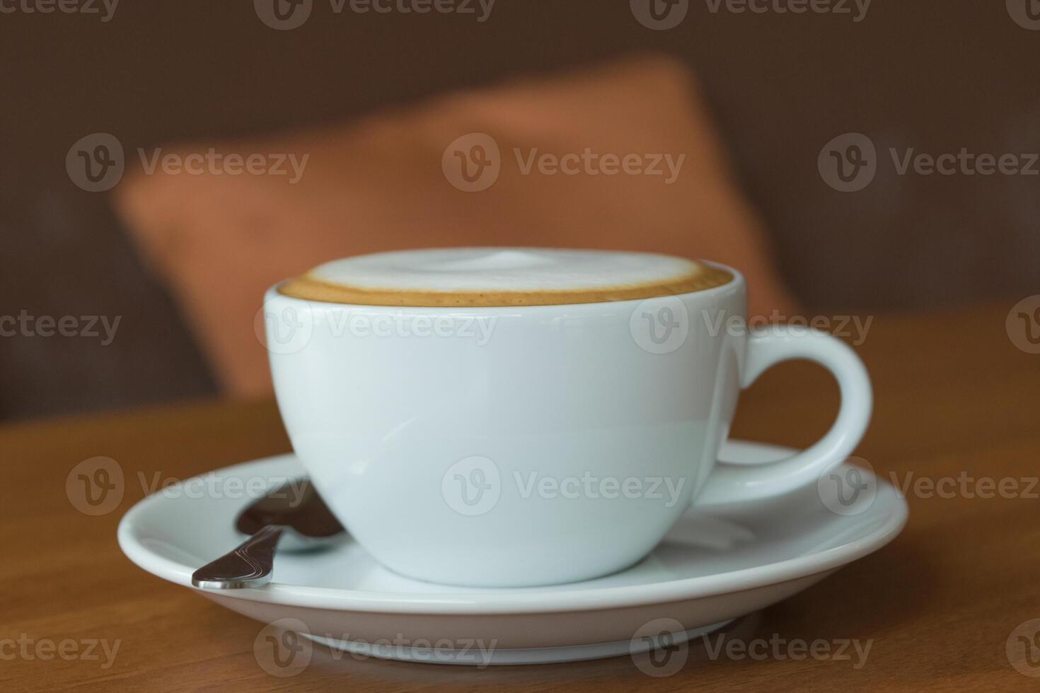 A white cup of coffee sitting on a saucer photo