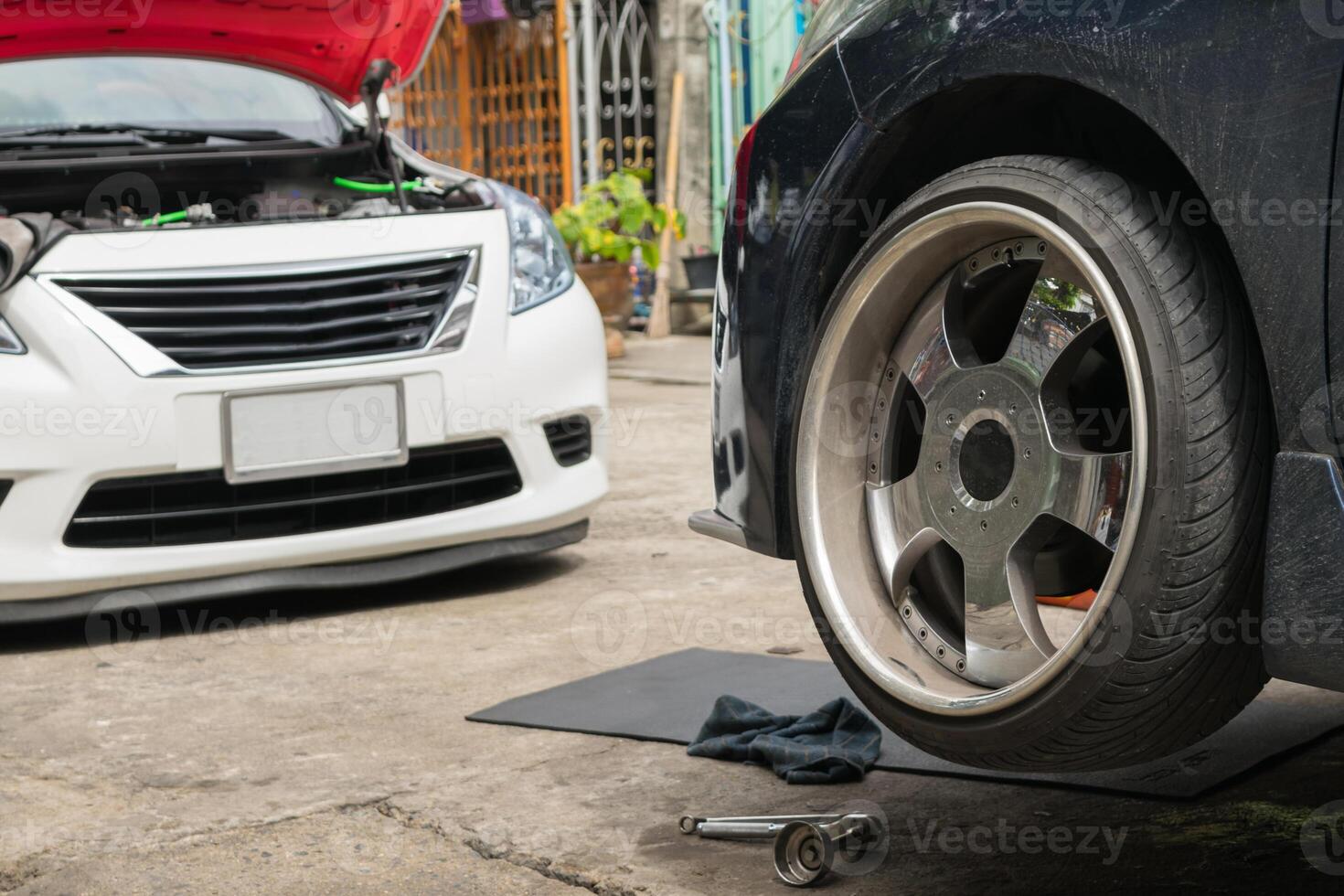 A car is being repaired with a tire on the ground photo