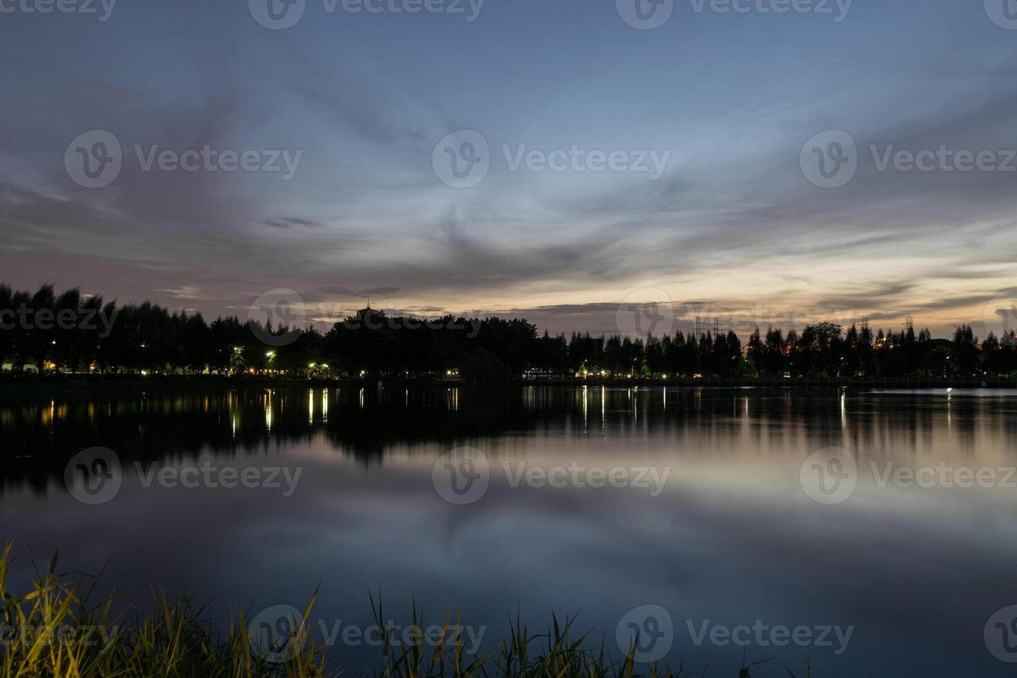 A lake at dusk with a park in the background photo