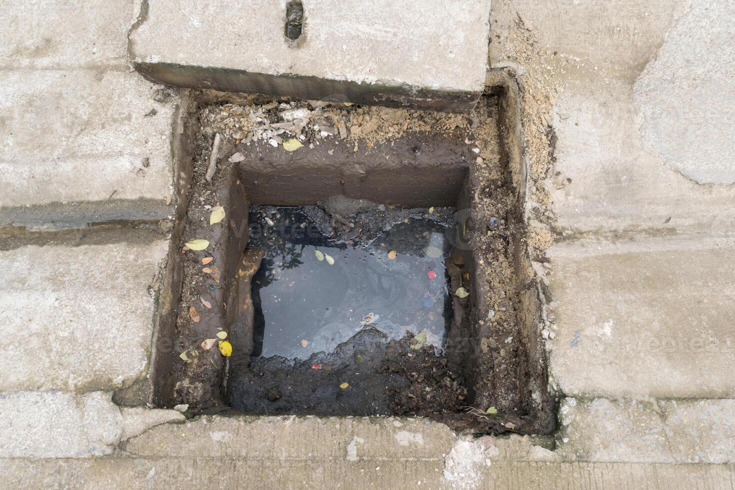 A hole in the ground with a small hole in it photo