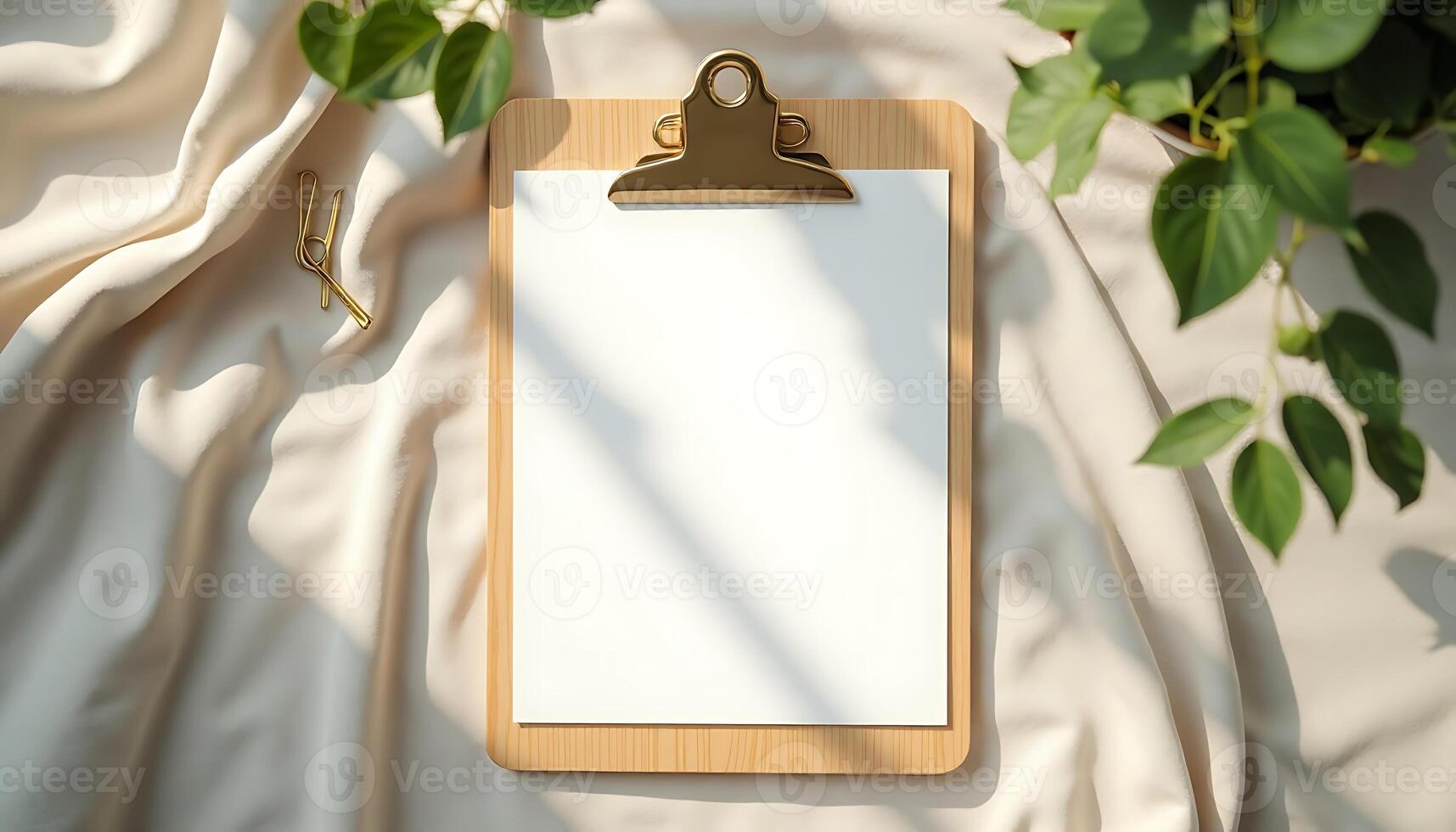 Clipboard with Blank Paper on Fabric with Houseplant and Paperclip photo
