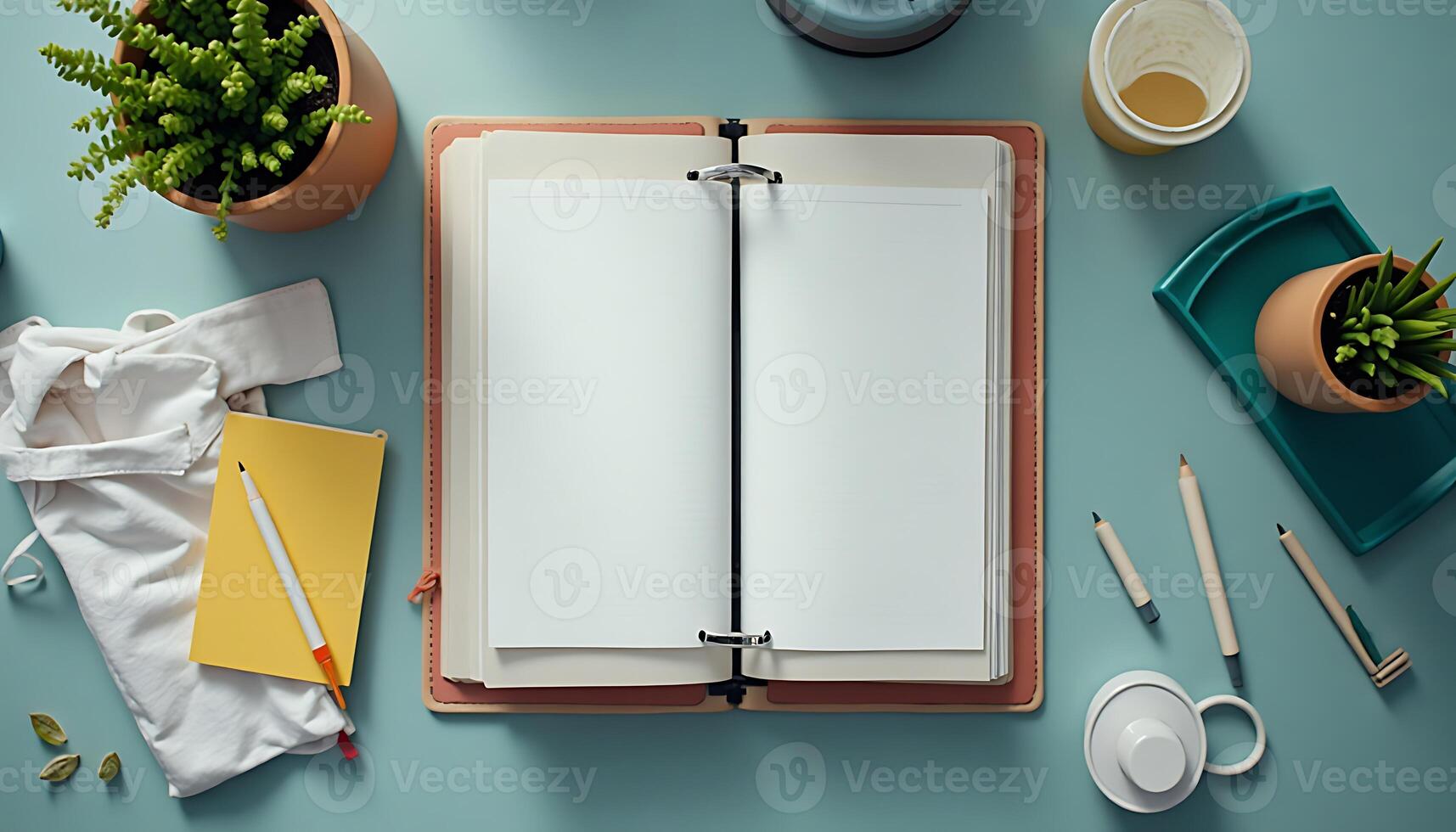 Open Blank Notebook on Blue Desk with Plant and Office Supplies photo