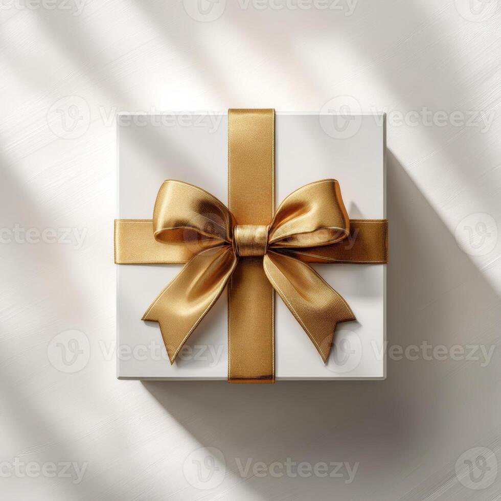 Golden gift box with ribbon and bow on white background photo