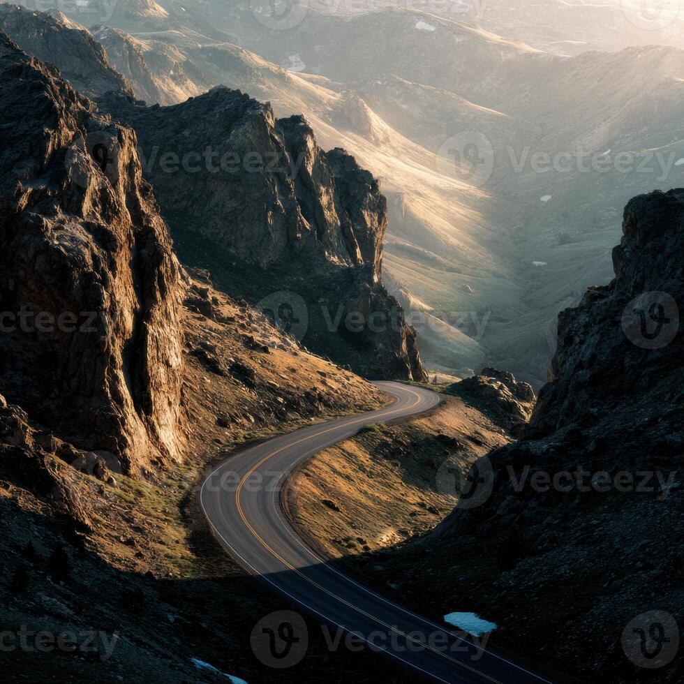 A winding road in the mountains with a mountain range in the background photo