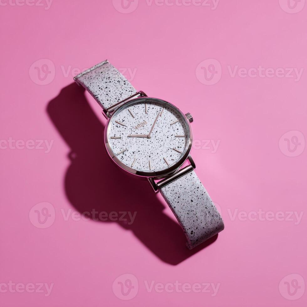 A silver watch on a pink background photo