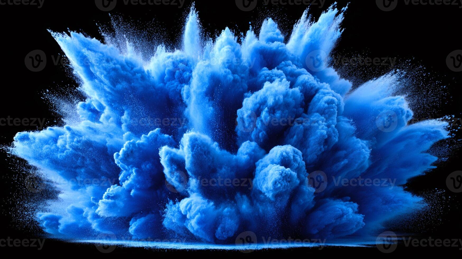 Blue powder exploding creating a vibrant cloud on black background photo