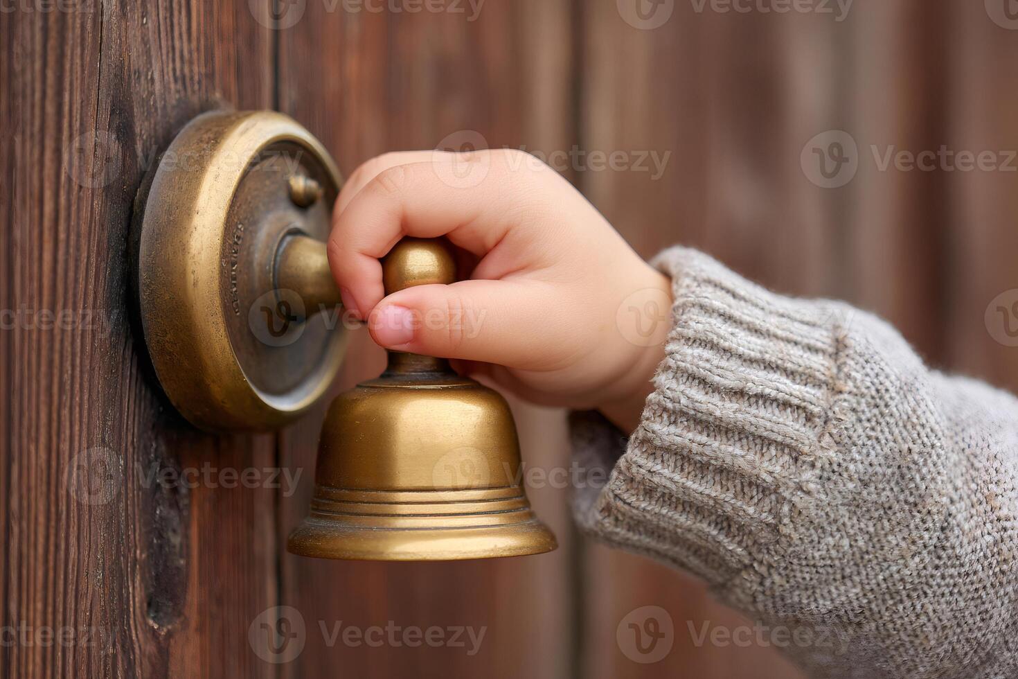 Child's hand ringing vintage brass doorbell photo