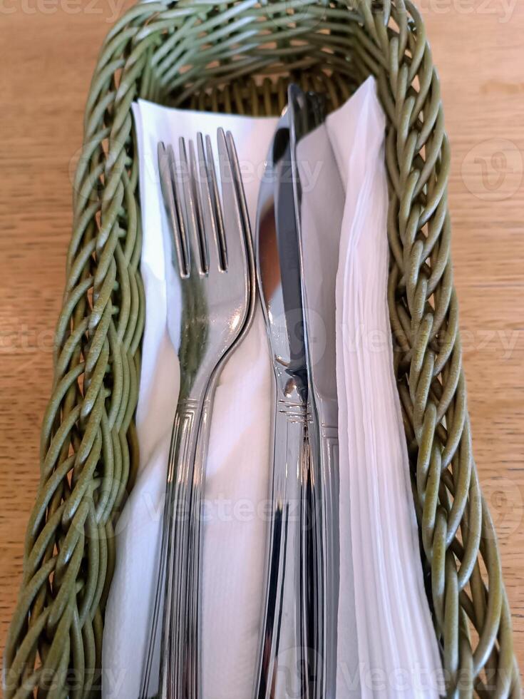 utensils on table in basket with napkins restaurant cafe cozy home serving waiter meal dinner photo