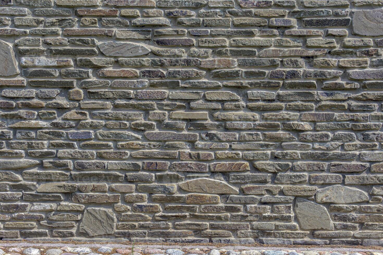 The wall of the castle is made of uneven, flat stones of various dark shades. Abstract background. photo