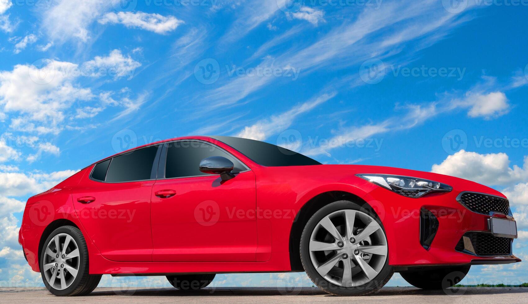 Red car on a blue sky background with white clouds. A modern, bright image of an avto mobile for design solutions. photo