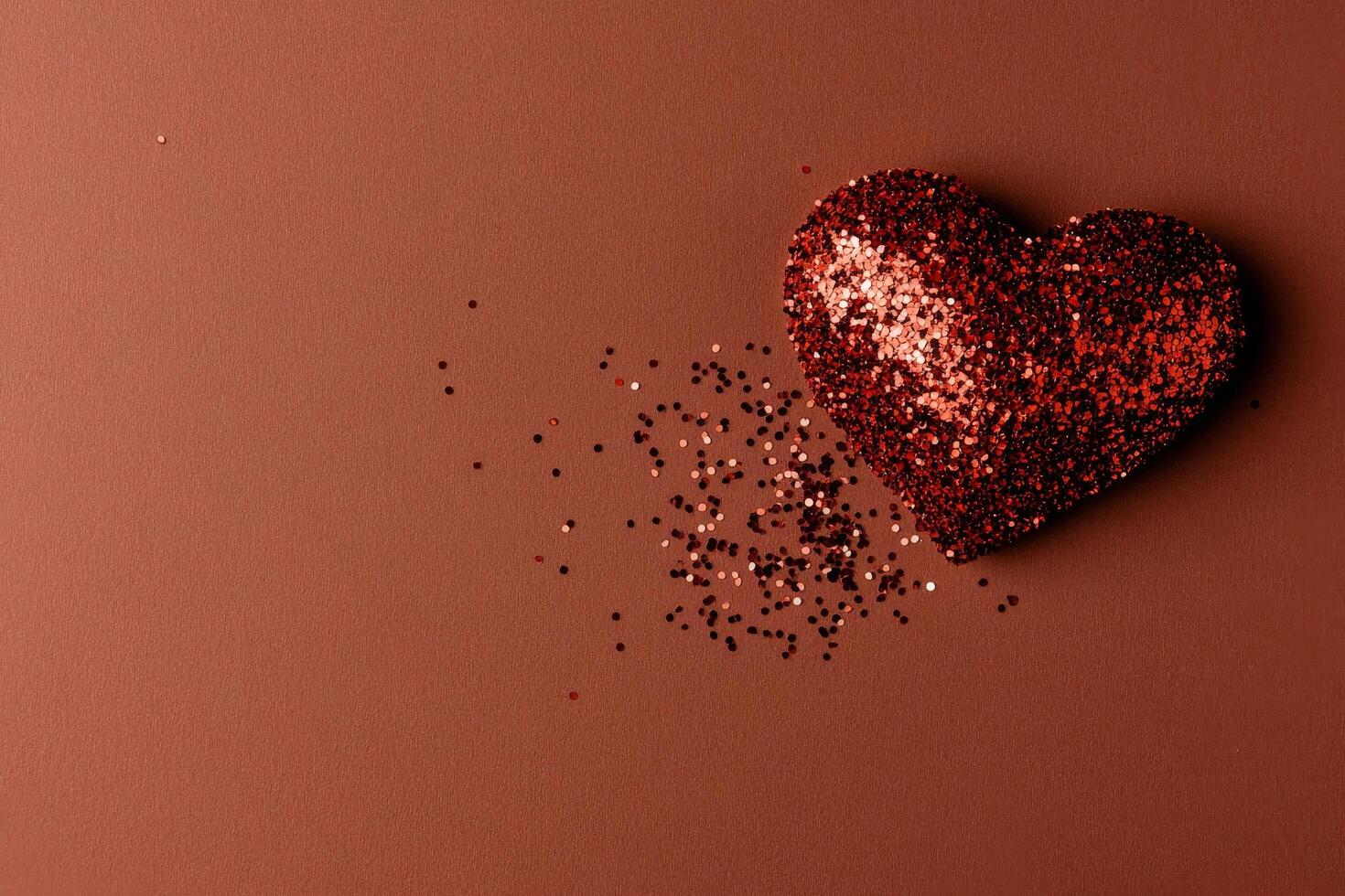 Colorful Glitter Heart on Brown Background With Scattered Sparkles for Celebration or Decoration photo