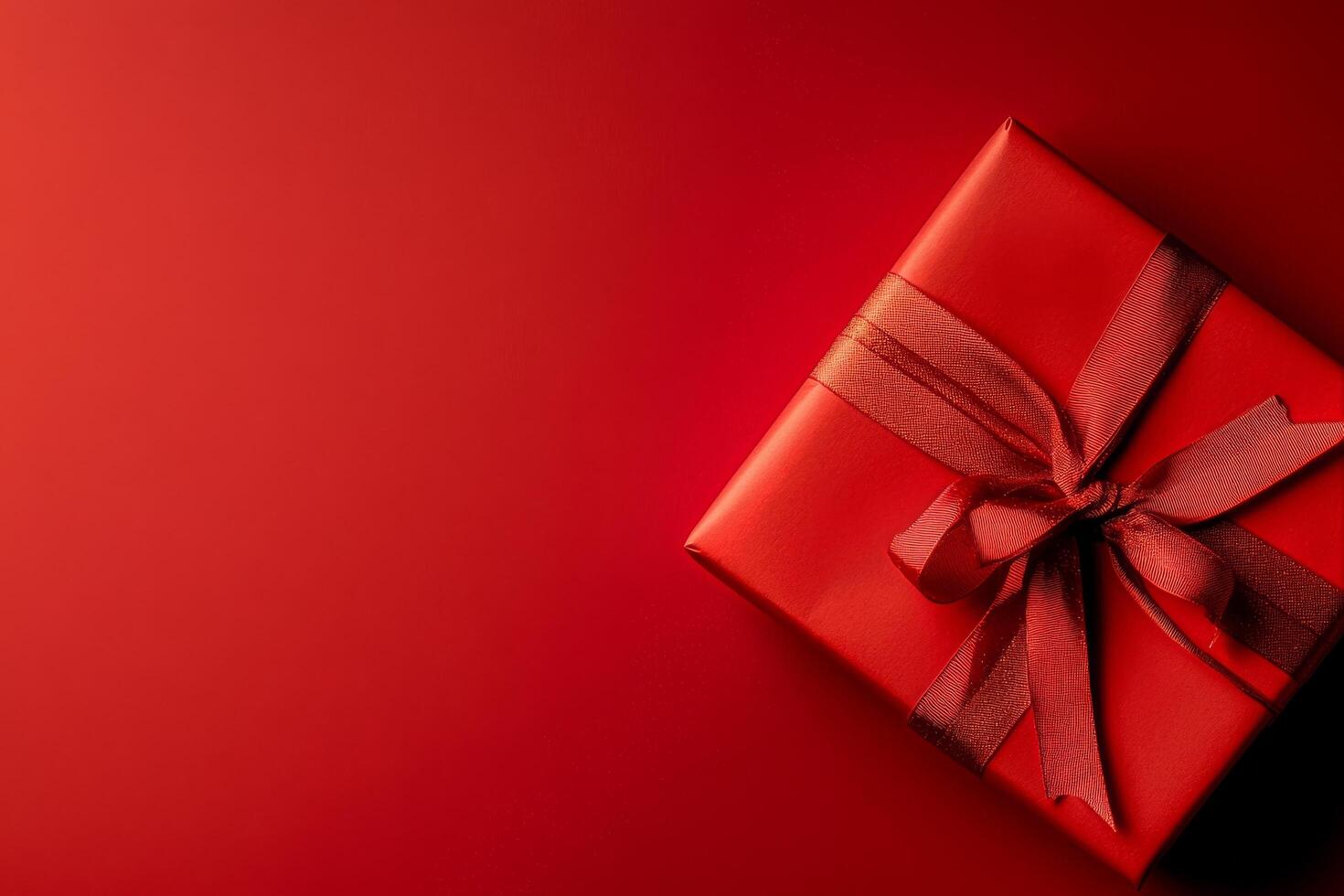 Gift Wrapped in Red Ribbon on Vibrant Red Background for Celebrations or Special Occasions photo