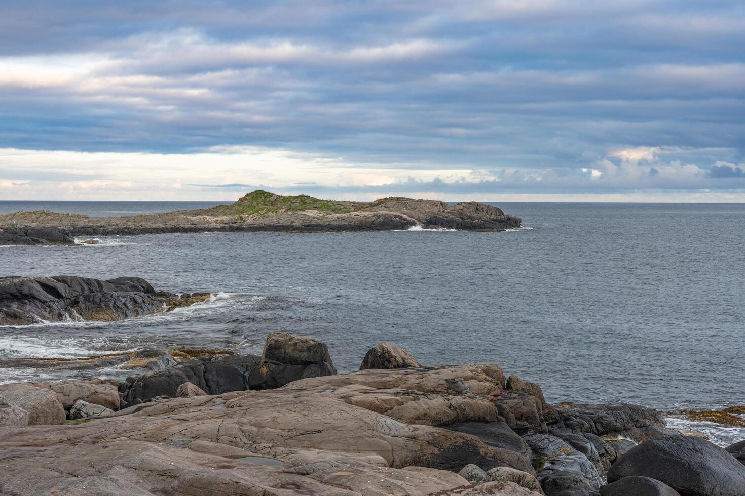 Rocky islands with waves crushing ocen view, Lofoten Norway photo