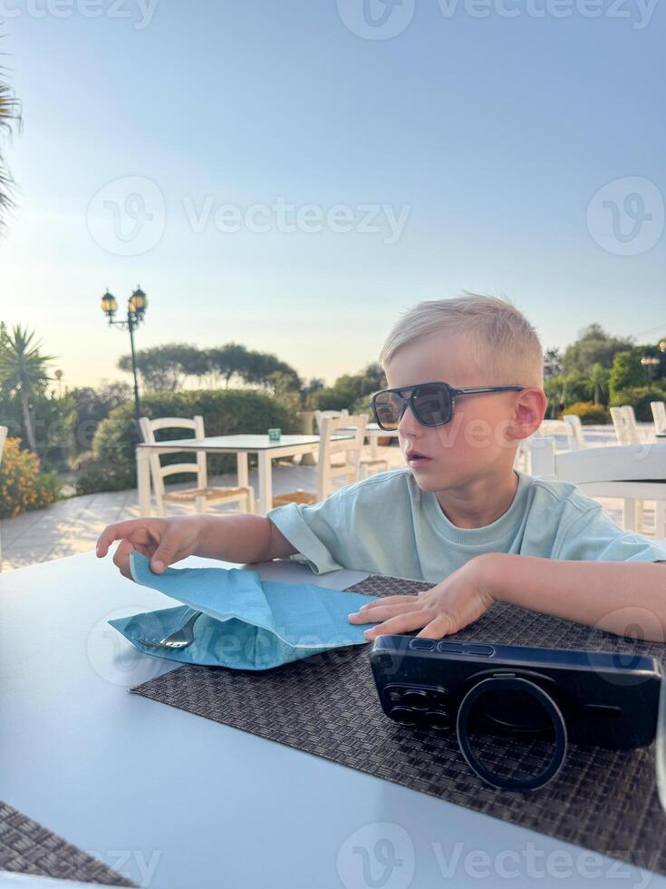 Young Boy Relaxing Outdoors with Sunglasses photo