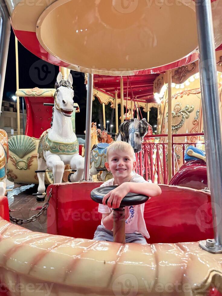 Child Enjoying Carousel Ride at Night Carnival photo