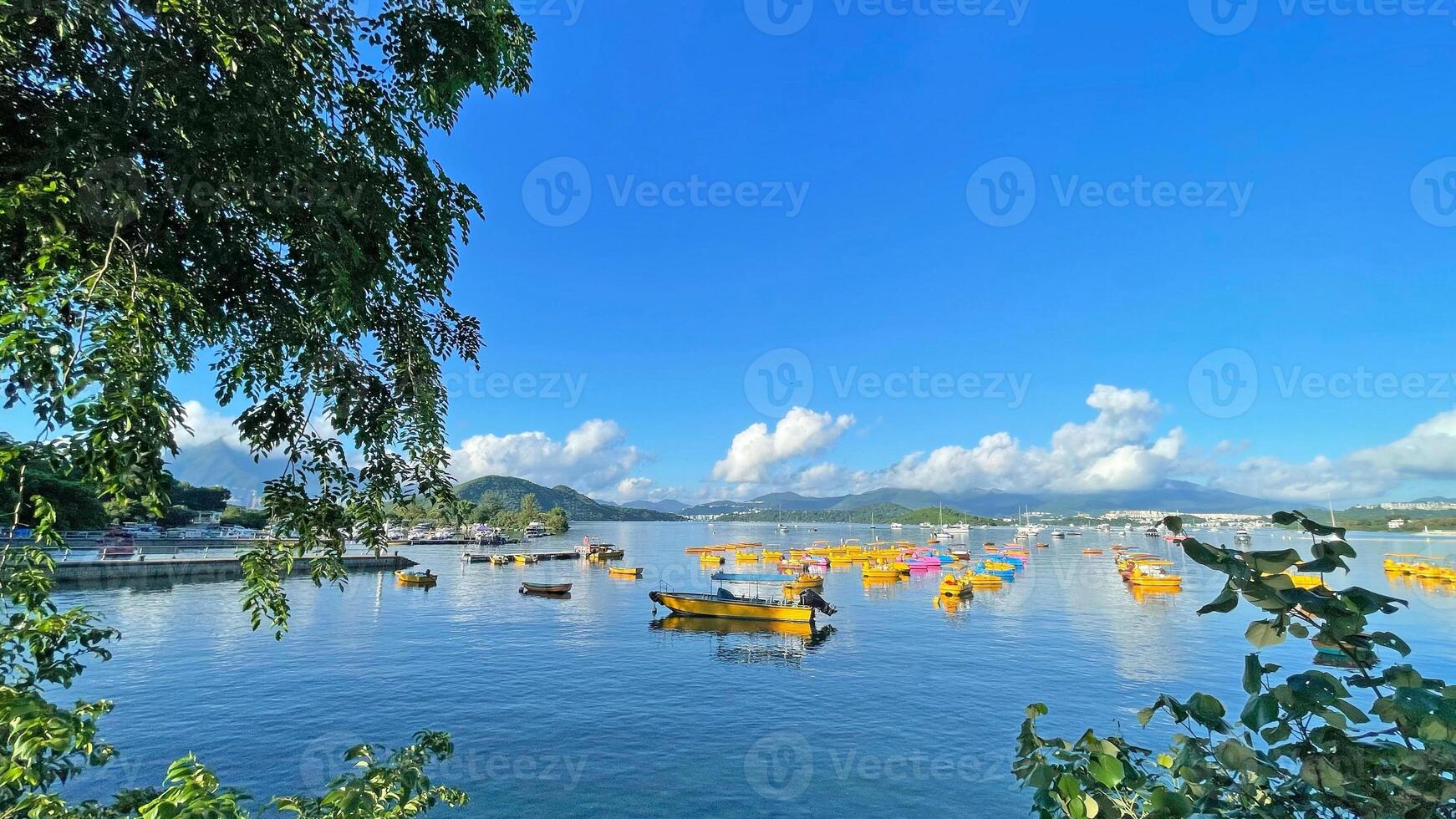 Fishing, recreational boats, natural background with trees, clouds, blue sky and mountains photo