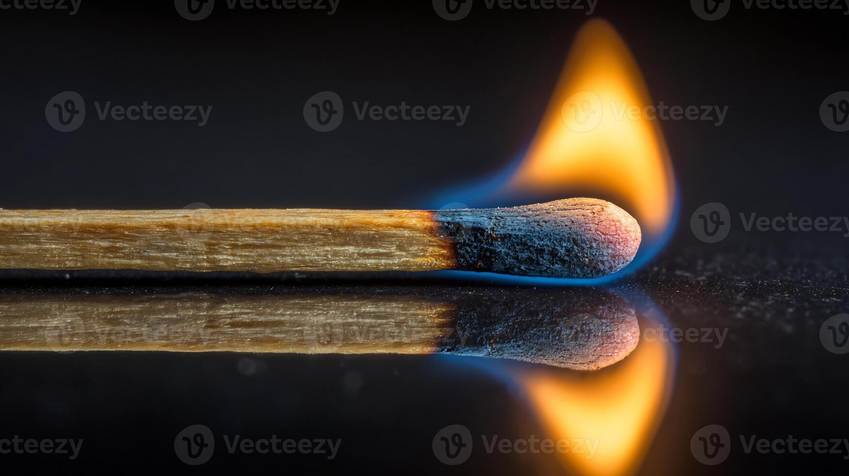 Macro shot of a wooden matchstick ignited with a fiery, blue-orange flame. photo