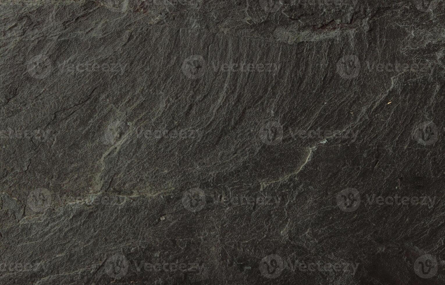 Close-up of natural dark slate stone surface with rough, layered texture photo