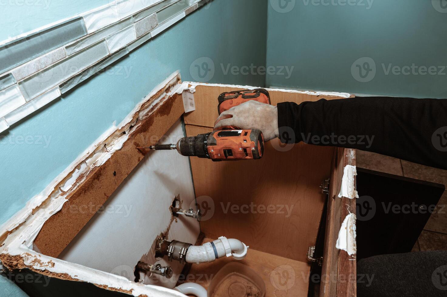 Handyman replacing an old bathroom cabinet. Plumbing repair service, assembling and install concept. copy space for text photo