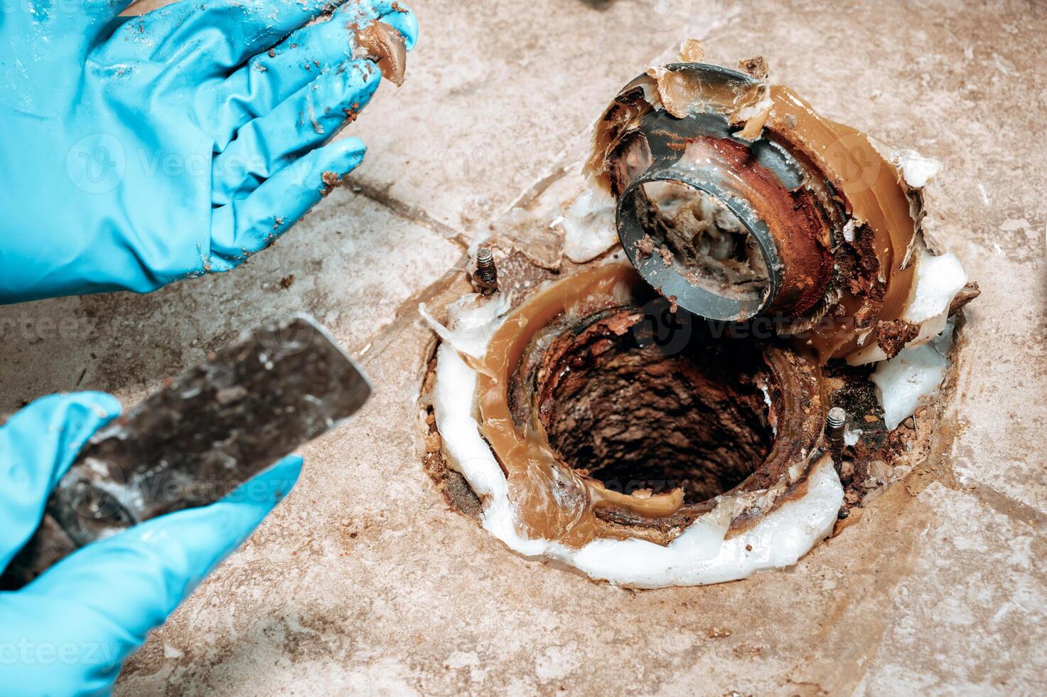 Detailed image of the toilet base area with wax ring placement during plumbing maintenance,. photo