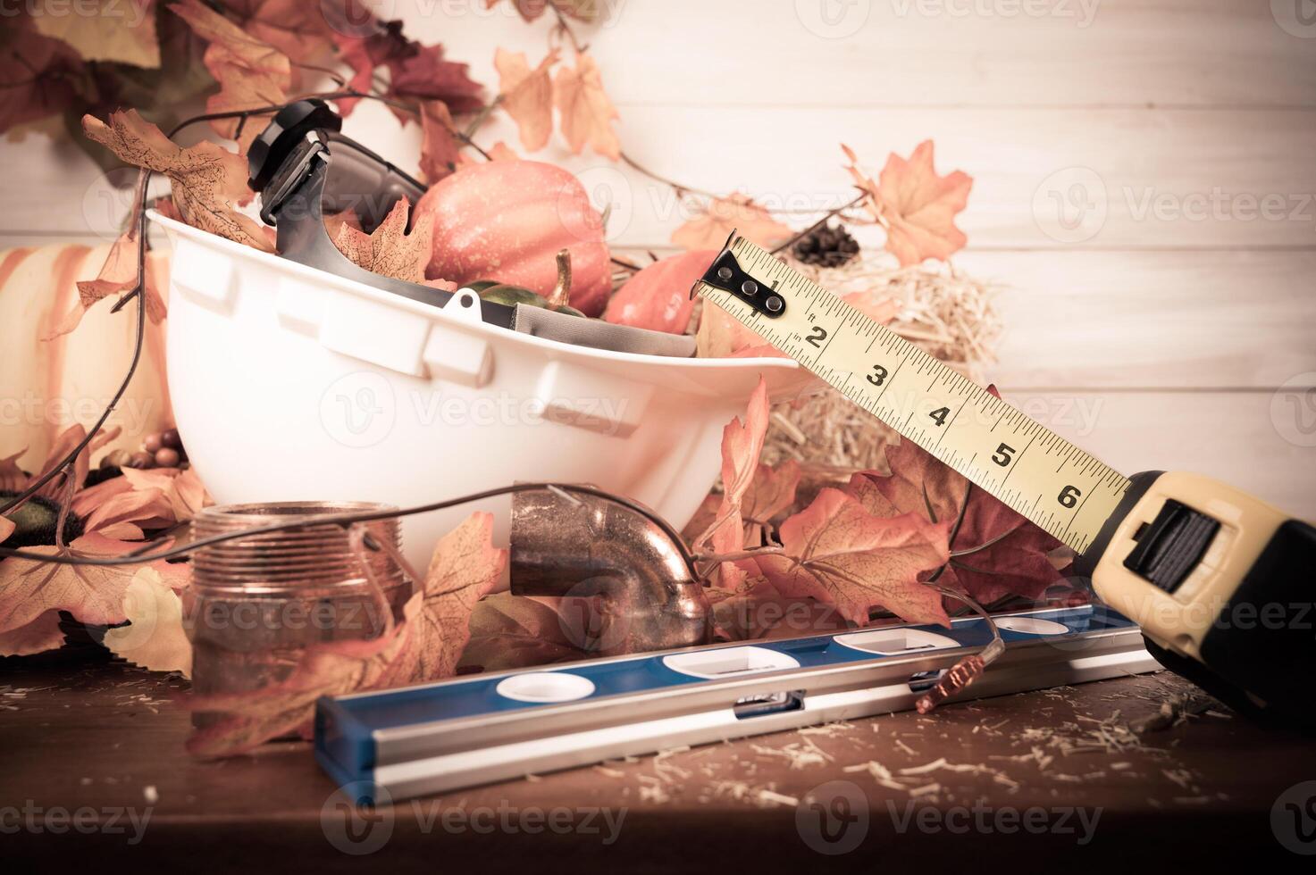 Thanksgiving with construction tools, maple leaves and pumpkin on wood background. Autumn composition with copy space. photo