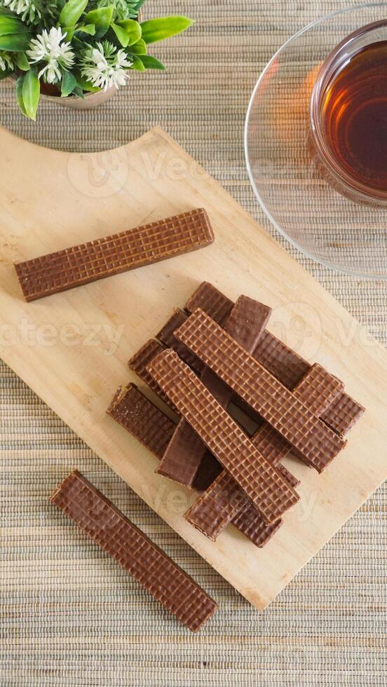 Chocolate wafer sticks on wooden board photo