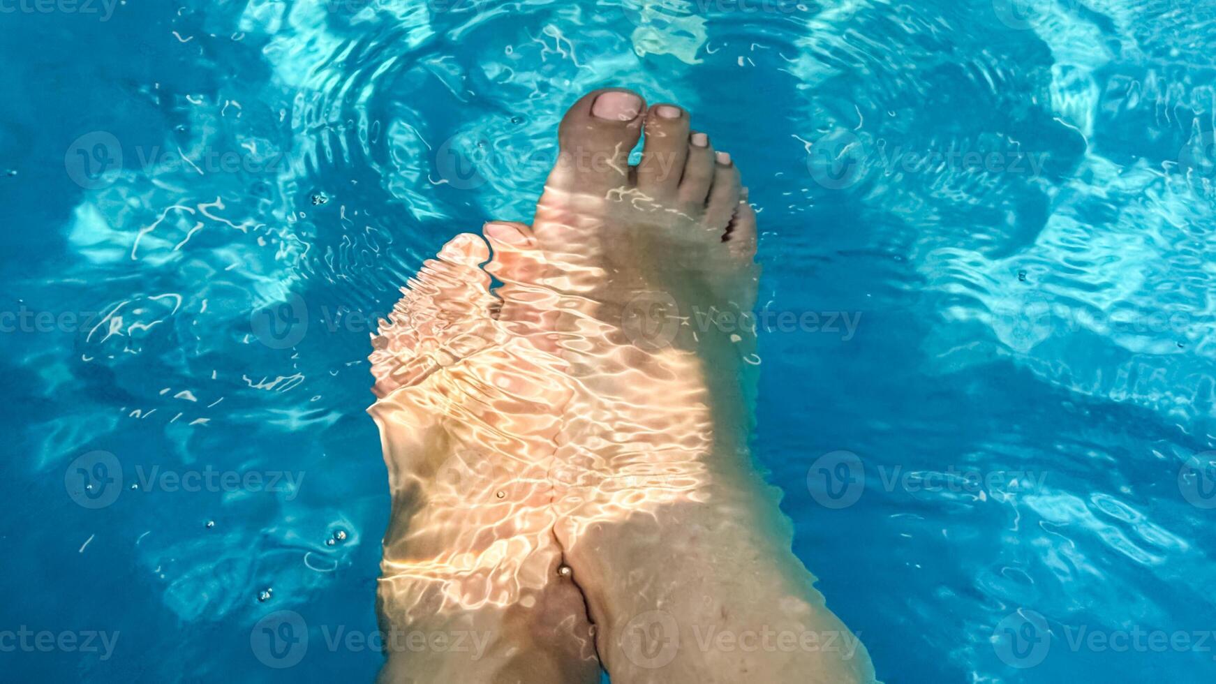 Sunlit feet shimmer beneath crystal ripples, evoking summery tranquility and International Barefoot Day vibes photo