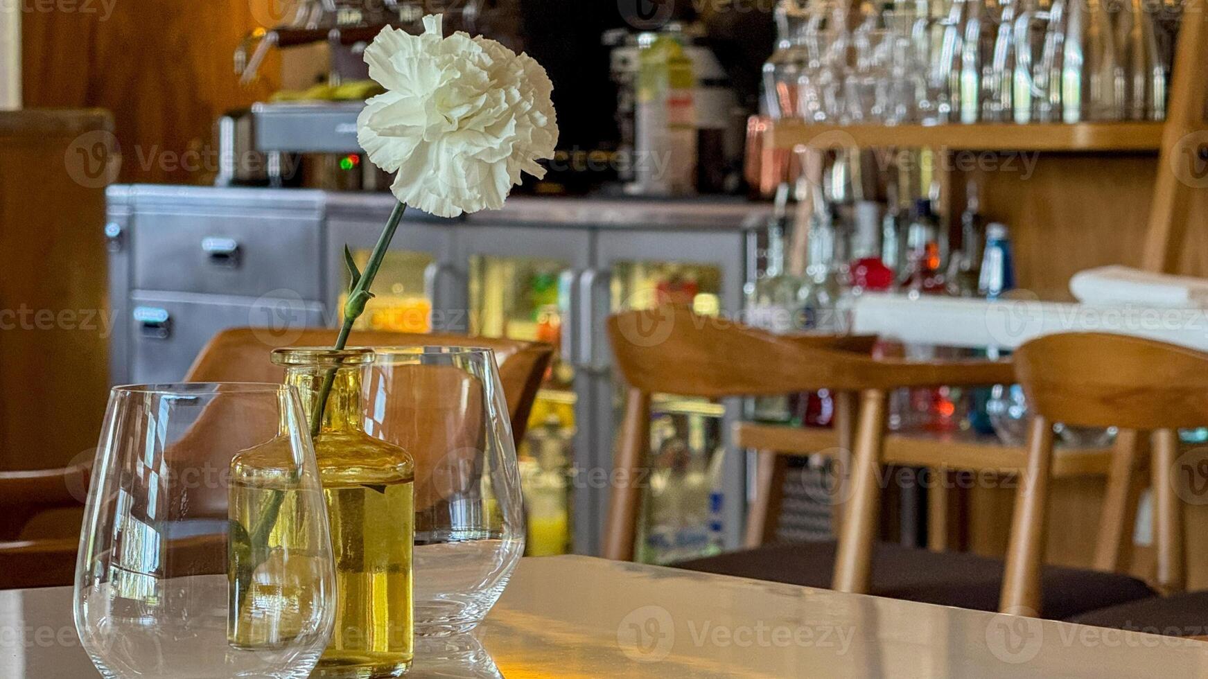 A single white carnation defies gravity in amber glass, channeling quiet elegance of Cafe de Flore nostalgia or Dia de los Muertos photo