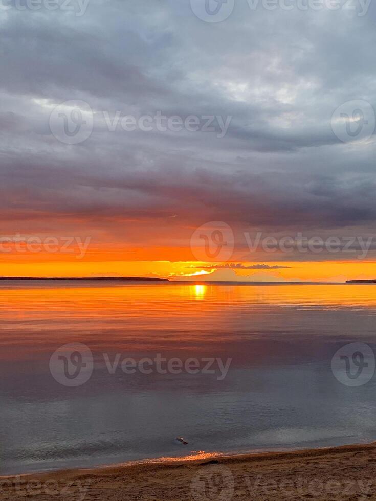 A mesmerizing sunset sets fiery whispers across a tranquil lake, evoking serene introspection on Sukkot and Earth Day photo