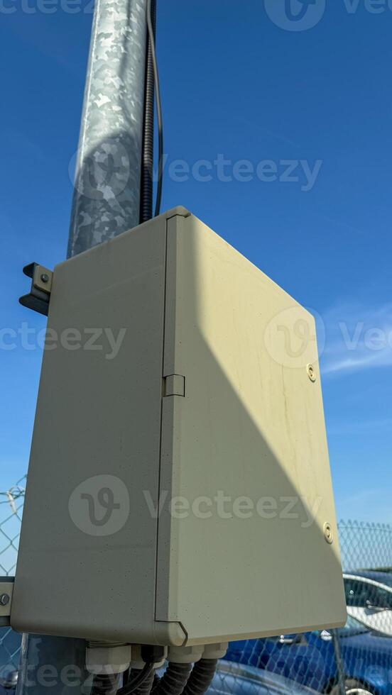A solitary beige electrical box against azure skies whispers secrets of urban design and International Data Privacy Day photo