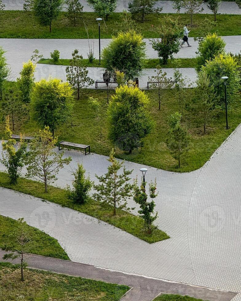 Paved labyrinth amid whispering trees, an Asian male jogger embraces serene urban harmony, perfect for Silent Walk Day photo