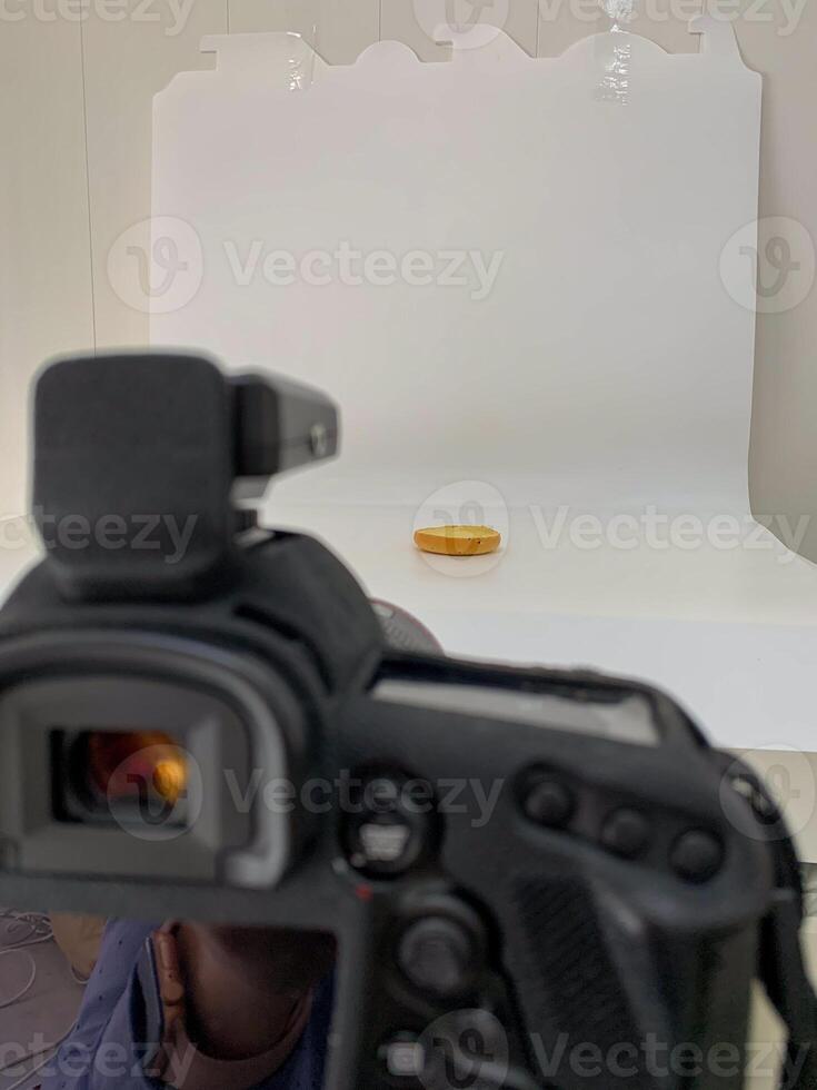 Lens poised like a vigilant eye, capturing a solitary coin, evoking Plutus silent wealth, perfect for World Thrift Day photo