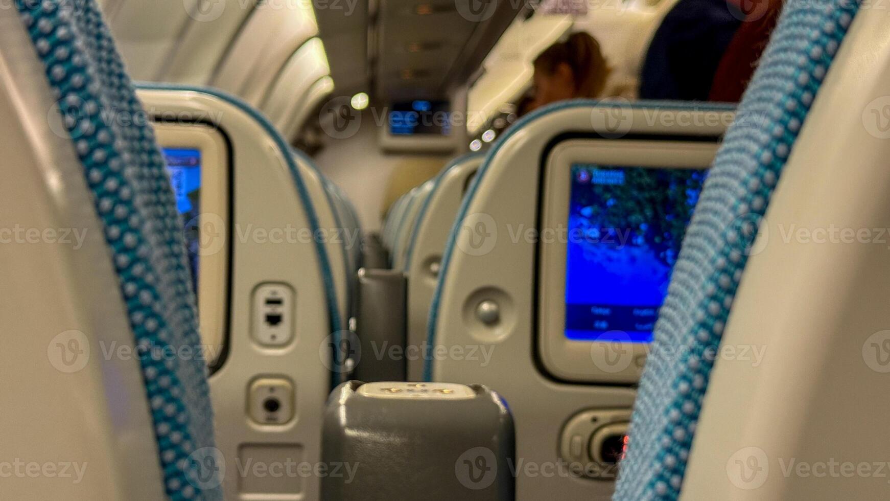 In flight entertainment screens glow softly on a bustling passenger aircraft, evoking Digital Detox Day and Trans Siberian Odyssey dreams photo