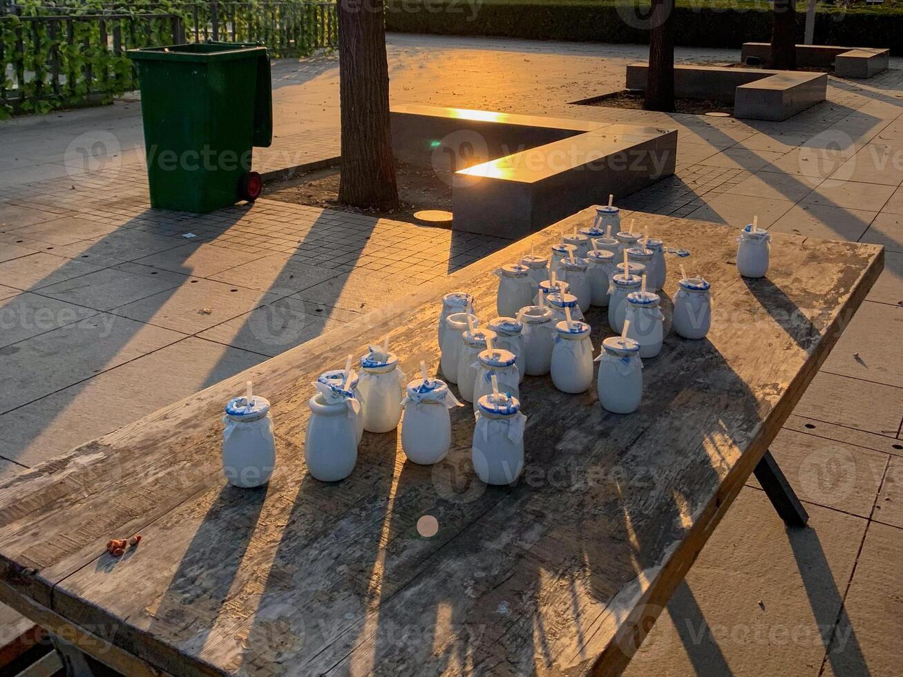 Ceramic milk jars bask in golden sunset, echoing rustic artisan markets and celebrating National Clay Week with tactile artistry photo