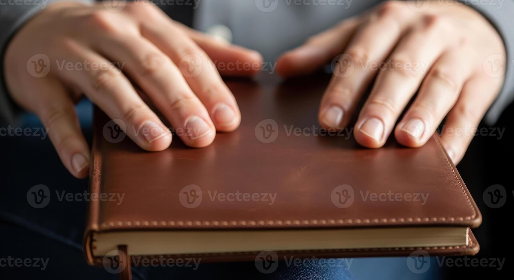 Hands rest on a brown leather notebook, ready for writing photo