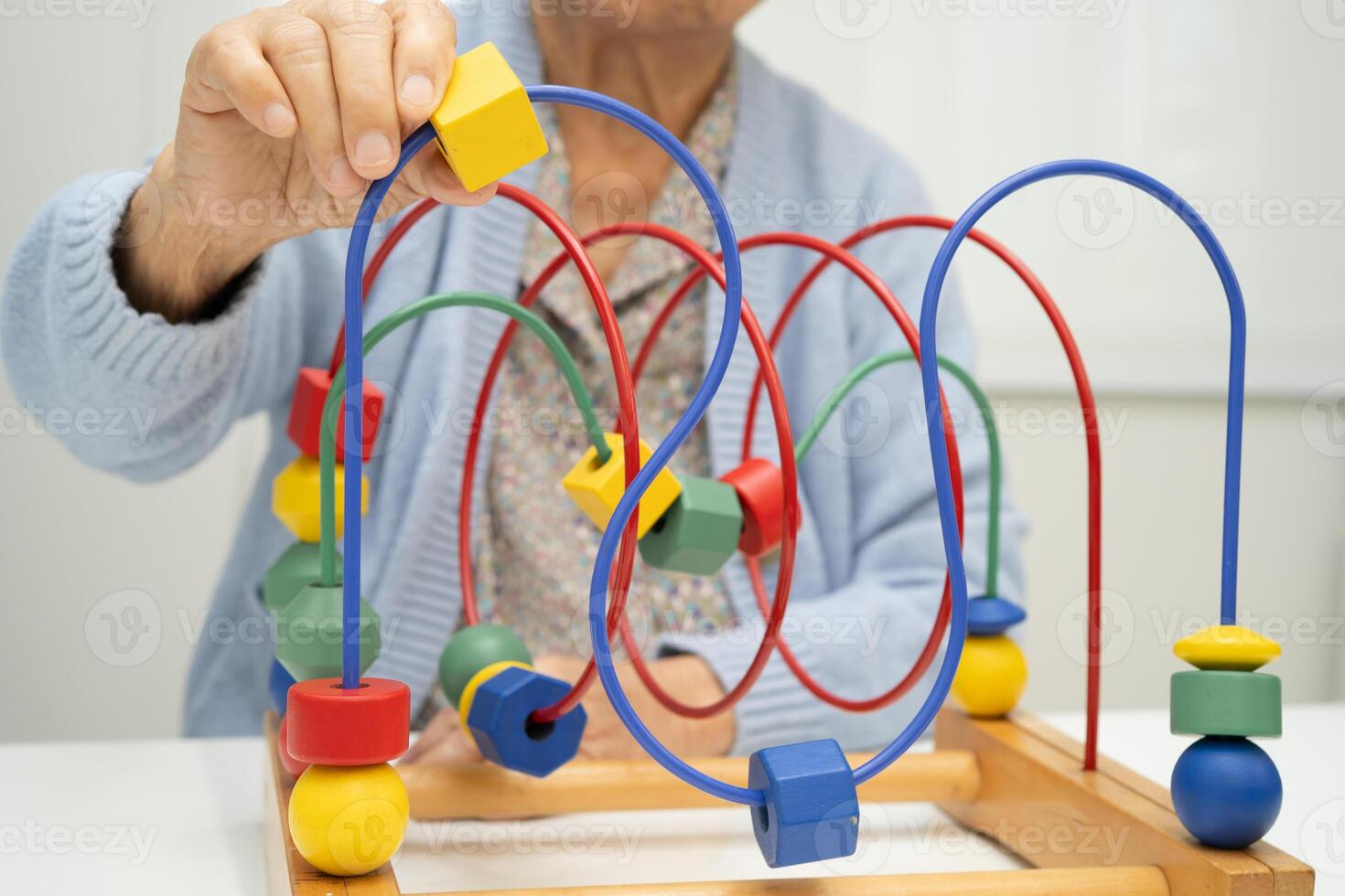 elderly woman playing skill game at home photo
