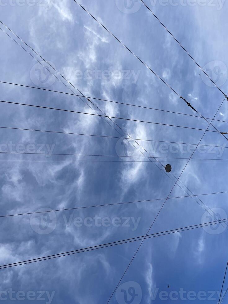 Dramatic Clouds Interwoven with Cables Form an Artistic Contrast Against a Clear Blue Sky photo