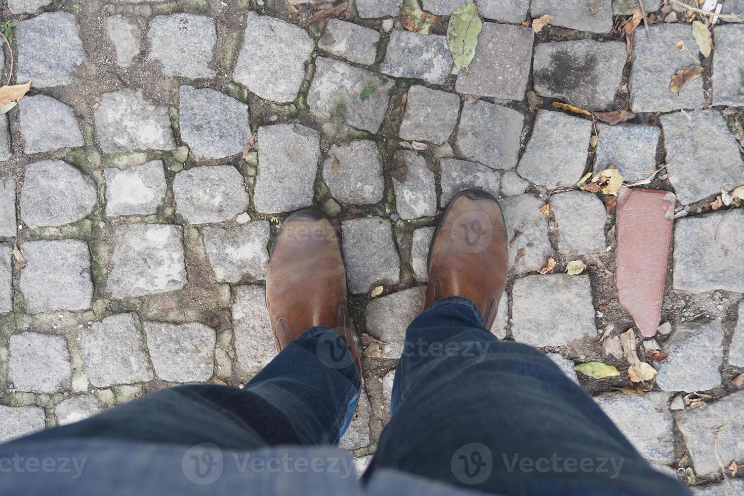 Walking on cobblestones while wearing brown boots photo